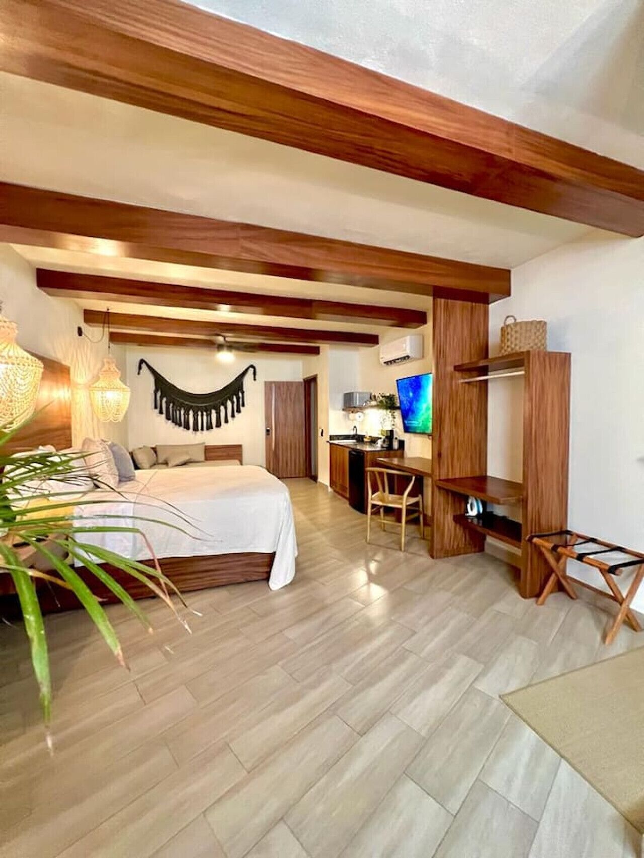 Une chambre à coucher comprenant un lit, une table de chevet et un coin bureau avec une chaise.