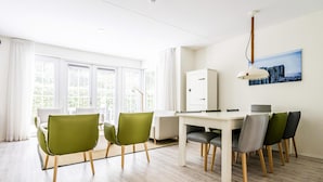 A modern room with a dining table, chairs, a cabinet, and a painting on the wall. - Apartment Near Koudekerke Beach (Koudekerke)