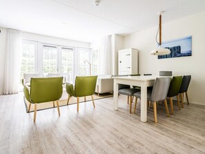 A modern room with a dining table, chairs, a cabinet, and a painting on the wall. - Apartment Near Koudekerke Beach (Koudekerke)