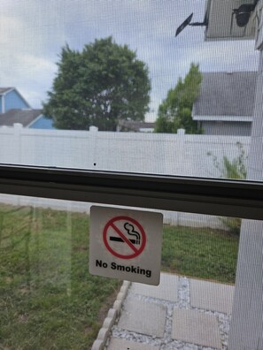 Un panneau « Il est interdit de fumer » est affiché sur une vitre.