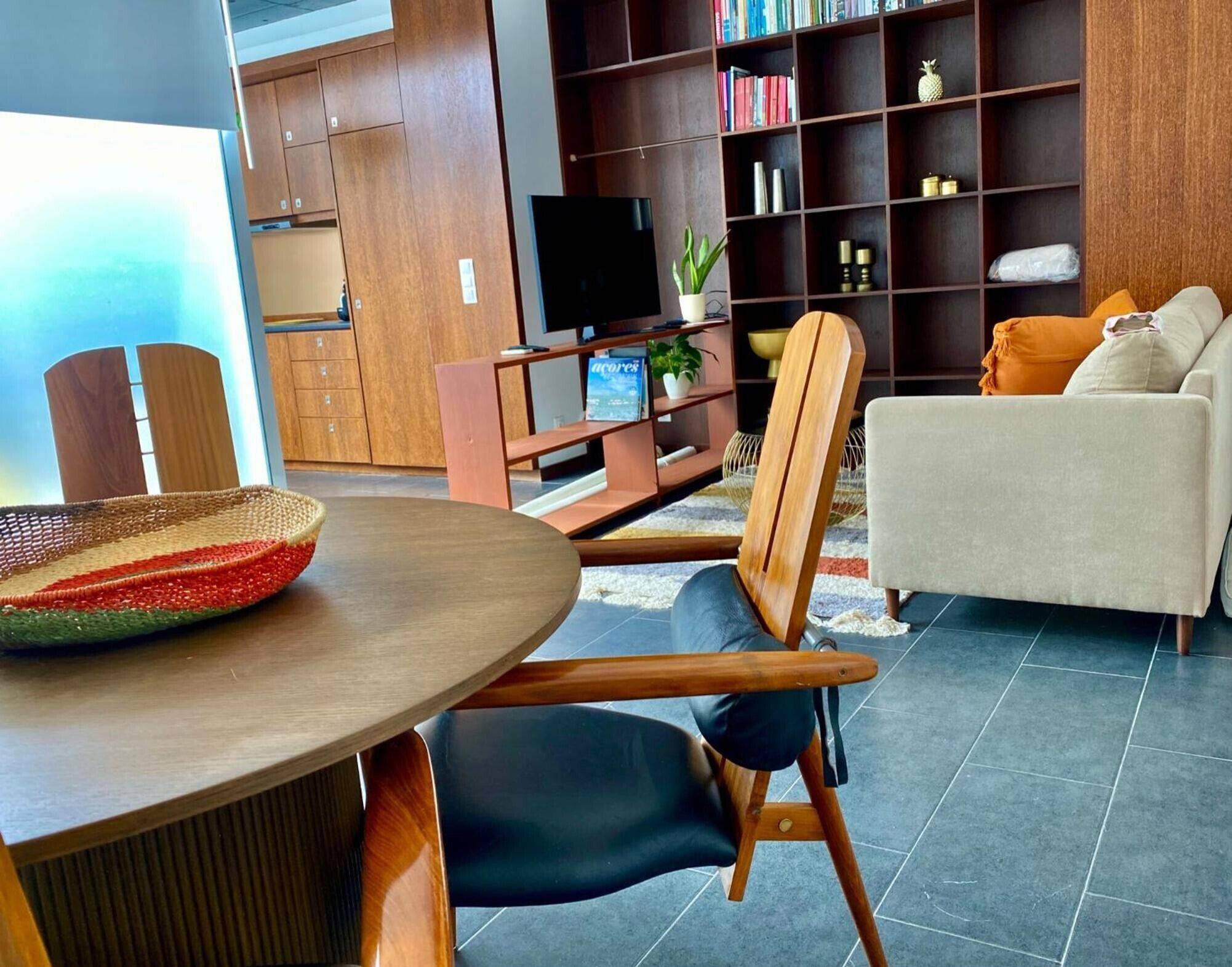 Un salon moderne comprenant un coin repas, un canapé, un téléviseur et une bibliothèque.