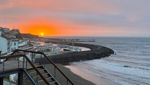A coastal scene with a sunset, a pier, and a staircase leading down to the beach. - 'Casa Maramar' – with Wi-Fi and Air Conditioning (Angra do Heroísmo)