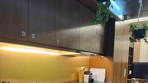 A modern kitchen with wooden cabinets, a stainless steel sink, and a built-in oven. - 'Casa Maramar' – with Wi-Fi and Air Conditioning (Angra do Heroísmo)