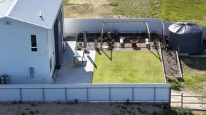 Una propiedad residencial con patio cercado, zona de patio y un tanque de agua grande.
