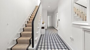 Ein modernes Interieur mit einer Treppe, einem Schachbrettfußboden und einer weißen Wand.