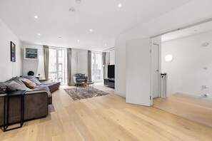 Ein modernes Wohnzimmer mit einer Couch, einem Couchtisch und einem Fernseher.