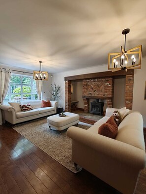 Ein Wohnzimmer mit Kamin, zwei Sofas, einem Couchtisch und einem Teppich.