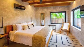 Une chambre avec un lit, un ventilateur de plafond, une fenêtre donnant sur un beau paysage et une chaise.