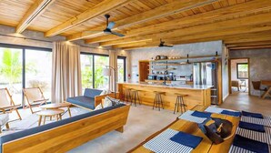 Ein modernes Interieur mit Holzbalkendecke, einer Bar und Sitzgelegenheiten.