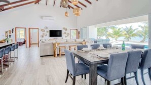 Un grand espace de vie comprenant une table à manger, des chaises, un canapé et un téléviseur.
