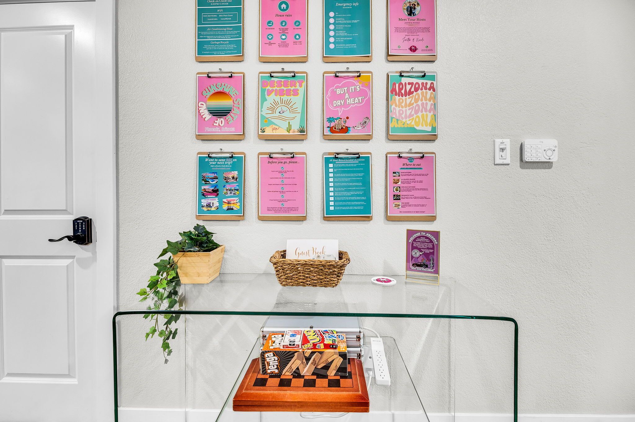 A wall with various informational posters, a guest book, a chess set, and a small plant.