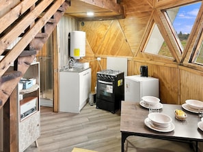 Una cocina compacta con estufa a gas, refrigerador y calentador de agua.