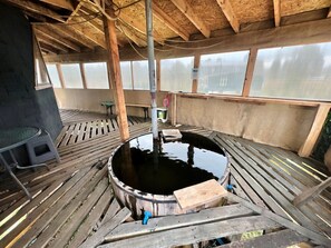 A wooden deck with a circular water feature, a bench, and a table.
