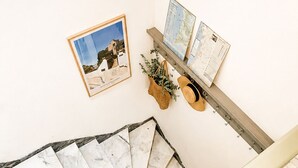 Eine Treppe mit Handlauf, eine gewebte Matte unten, ein gerahmtes Bild und eine Karte an der Wand.