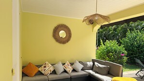 Ein modulares Sofa mit gemusterten Kissen, ein gewebter Wandbehang und eine hängende Leuchte.