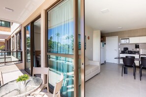 A modern apartment with a balcony, a dining area, and a kitchen. - Capri Residence (Ipojuca)