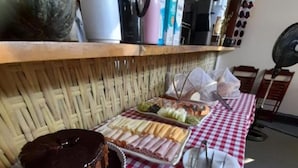 En buffetbord med dug i tern, en chokoladekage og forskellige spiser.