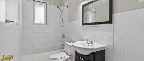 Un baño con bañera, inodoro y lavabo.