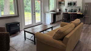 A modern kitchen with white cabinets, a stainless steel refrigerator, and a built-in oven. - New 1-bedroom house in Garfield Bay perfect for a relaxing getaway (Sagle)