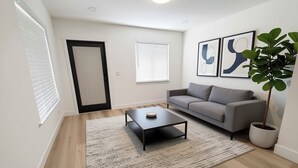 A modern living room with a sofa, a coffee table, a potted plant, and artwork on the wall. - Miami International Airport Stay/beautiful home in central location (Miami)