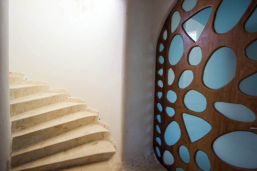 Een trap met een bijzonder houten wandontwerp met ronde uitsparingen.