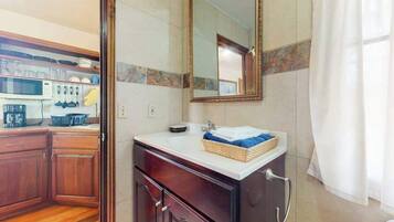 Une salle de bain avec un lavabo, un miroir et des meubles en bois.