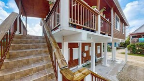 Un bâtiment à deux étages doté d’un escalier en bois et d’un porche couvert.