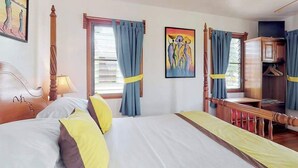 A hotel room with a large bed, a desk, a wardrobe, and a window with curtains. - Romantic cabana w strong WiFi & shared pool, grill, enclosed yard-close to beach (Hopkins)