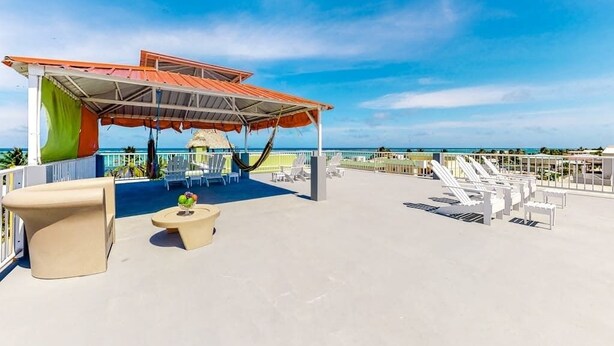 A rooftop terrace with a covered seating area, lounge chairs, and a view of the ocean. - Inviting apartment w WiFi & partial AC - steps from the ocean, walk everywhere (San Pedro)