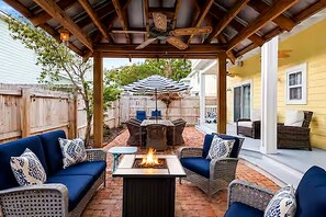 An outdoor patio with a fire pit, wicker furniture, and a ceiling fan. - Lemoncello Cottage 30A•Golf Cart+Bikes (Santa Rosa Beach)