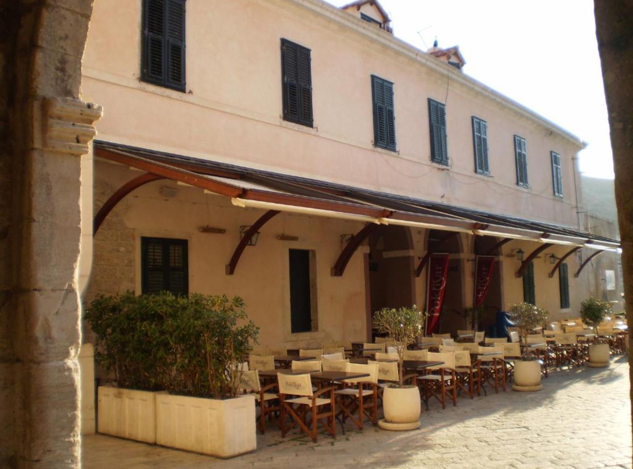A building with outdoor seating, a covered patio, and a sign that reads 'Ristorante.'