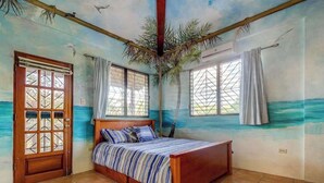 Een kamer met een bed, een deur en raamgordijnen.