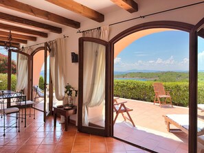 A room with a view of the sea, a wooden ceiling, and a table with chairs. - Il Delfino - Seaside Bliss (Golfo Aranci)