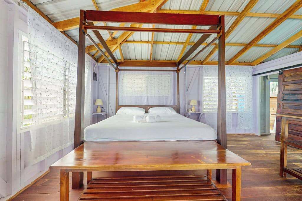 A room with a bed, wooden furniture, and a metal ceiling structure.