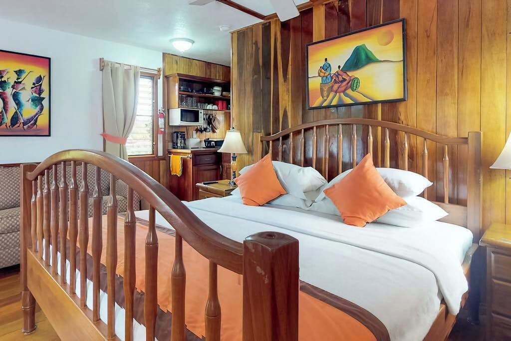 A bedroom with a wooden bed frame, a nightstand, a lamp, and a bookshelf.