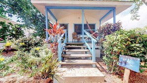 A building with a covered porch, a staircase leading to a door, and a sign indicating the name 'Blue Marlin.'