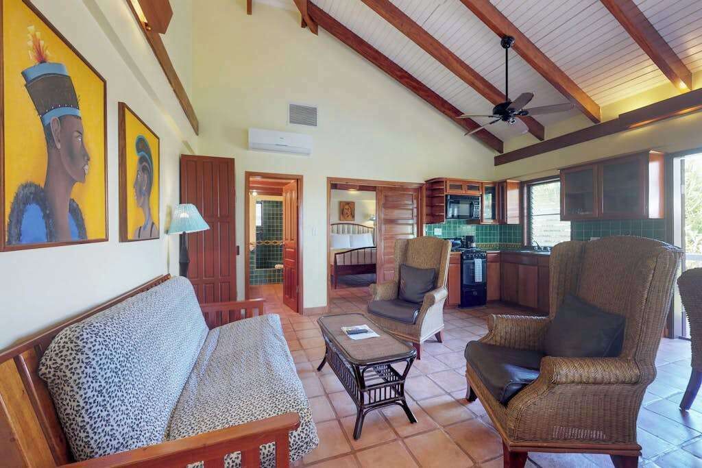 A spacious living area with a sofa, chairs, a coffee table, and artwork on the walls.