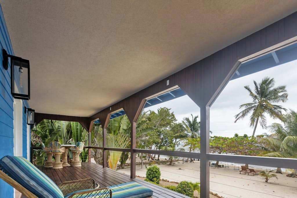 Un espace extérieur abrité, doté d’une terrasse en bois, de chaises longues et de plantes en pot.