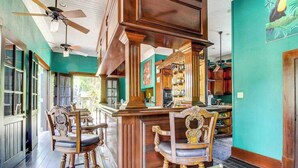 Zona de bar con sillas de madera y barra.