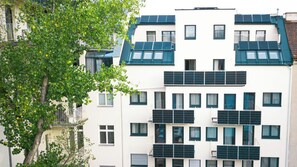 Un edificio de varios pisos con paneles solares en el techo y balcones.