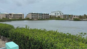 A waterfront hotel with multiple buildings, a body of water, and dense greenery in the foreground. - Escape to Paradise - Beautiful Lakeside Villa with pool access and WiFi (San Pedro)