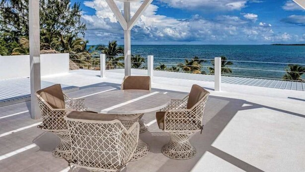 Een overdekt terras met uitzicht op zee.