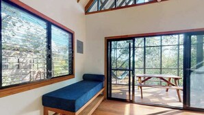 A room with a bench, large windows, and a view of the outdoors.