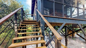 A wooden staircase leading to a building with large windows.
