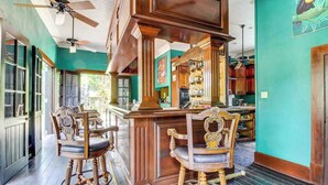 Uma área de bar com cadeiras de madeira e balcão.