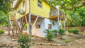 Una casa a due piani con una scala in legno che conduce a un balcone.
