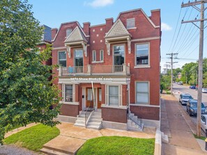 A two-story brick building with a balcony on the second floor, a front entrance, and a clear street view. - The Shaw Collective-Botanical Garden/ZOO/The GROVE/Tower Grove Park (St. Louis)