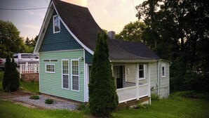 A small, single-story house with a porch, a chimney, and a white fence. - Tiny Home Away From Home - Complete Privacy, Peace (Watertown)