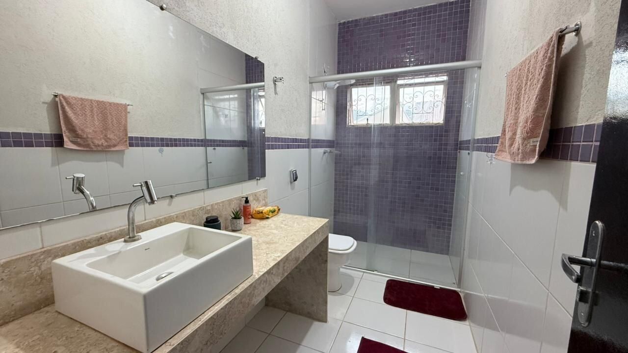 Une salle de bain avec un grand lavabo, un miroir, une douche et deux serviettes.