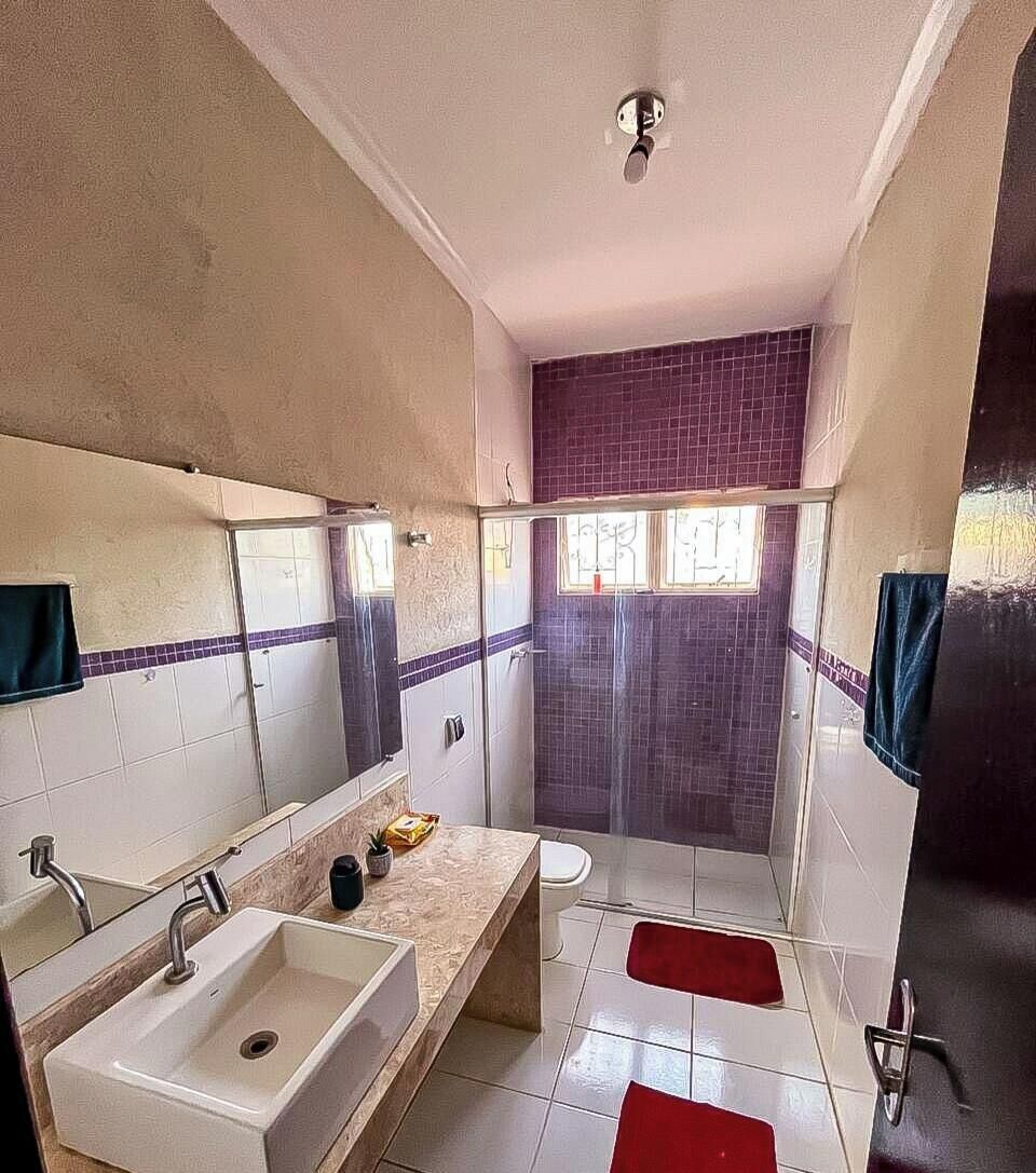 Un baño con lavamanos, espejo y ducha.